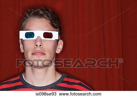 Stock Image - Young man wearing 3D glasses. Fotosearch