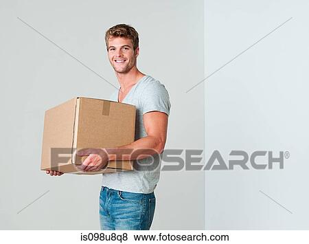 Stock Photo - Young man with cardboard box. Fotosearch