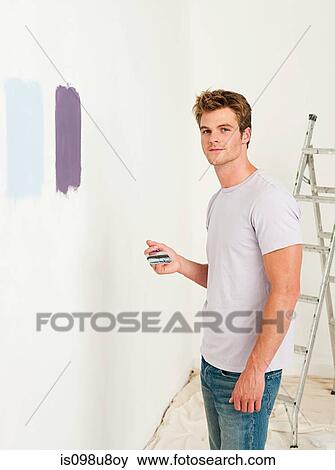 Stock Photo - Young man with paint on wall. Fotosearch