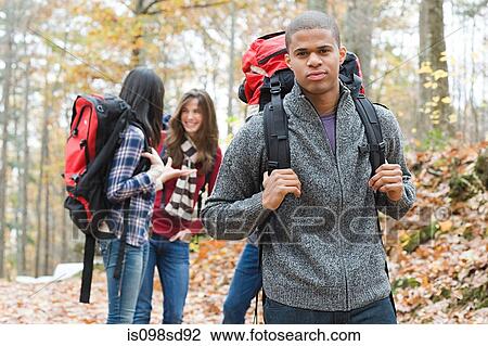 Young people hiking through forest View Large Photo Image Stock Image - Young people hiking through forest. Fotosearch