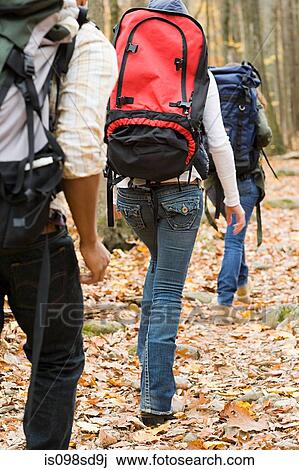 Stock Image - Young people hiking through forest. Fotosearch