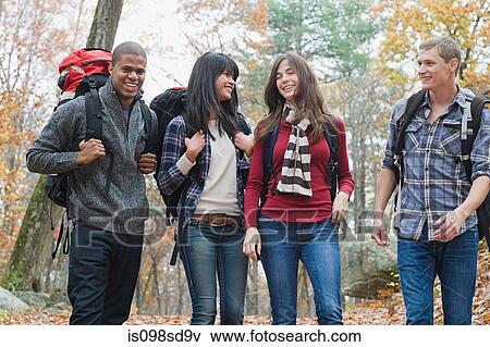 Stock Photo - Young people hiking through forest. Fotosearch