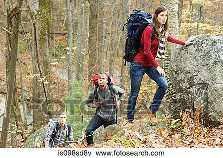 Stock Photo - Young people on boulders in forest. Fotosearch