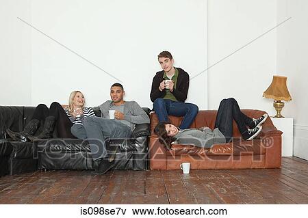 Young people on leather sofa View Large Photo Image Stock Photo - Young people on leather sofa. Fotosearch