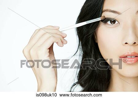 Young woman applying eye makeup View Large Photo Image Stock Image - Young woman applying eye makeup. Fotosearch
