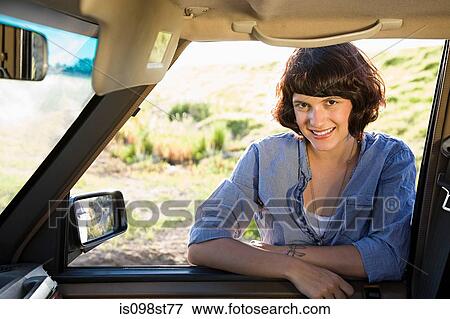 Stock Photo - Young woman by automobile. Fotosearch