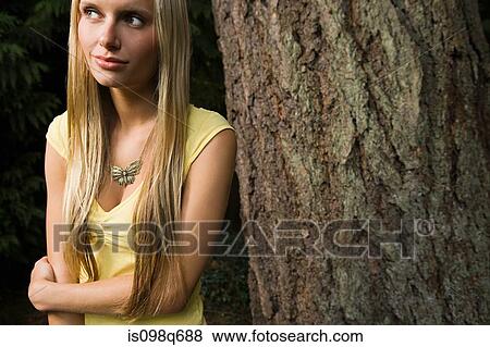 Stock Photo - Young woman by tree. Fotosearch