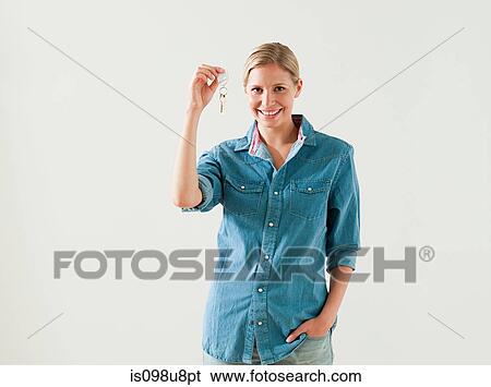 Stock Photograph - Young woman holding house keys. Fotosearch
