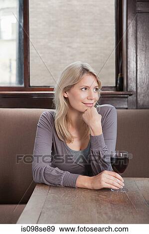 Stock Photo - Young woman in bar with red wine. Fotosearch