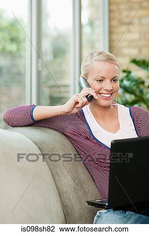 Young woman on cell phone at home View Large Photo Image Stock Image - Young woman on cell phone at home. Fotosearch
