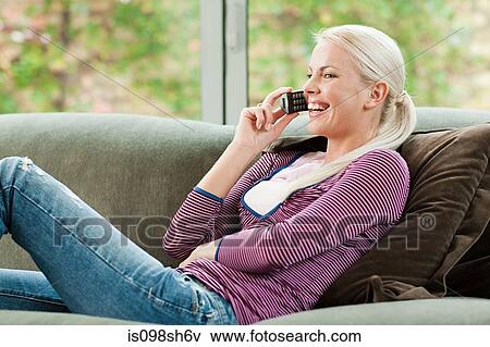 Young woman on cell phone at home View Large Photo Image Stock Photo - Young woman on cell phone at home. Fotosearch