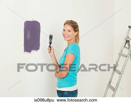 Young woman painting a wall View Large Photo Image Stock Photograph - Young woman painting a wall. Fotosearch