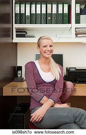 Young woman sitting in home office View Large Photo Image Picture - Young woman sitting in home office. Fotosearch