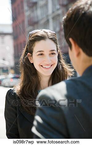Stock Photography - Young woman smiling at a man. Fotosearch
