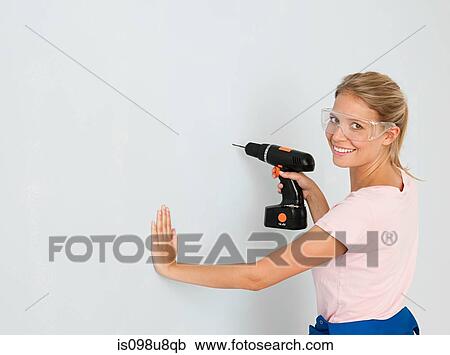 Young woman using electric drill View Large Photo Image Stock Image - Young woman using electric drill. Fotosearch