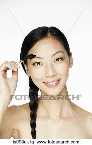 Young woman using eyebrow comb View Large Photo Image Stock Photography - Young woman using eyebrow comb. Fotosearch