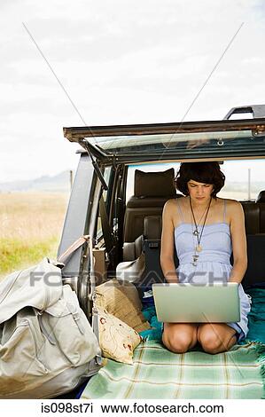 Young woman using laptop in back of suv View Large Photo Image Stock Image - Young woman using laptop in back of suv. Fotosearch
