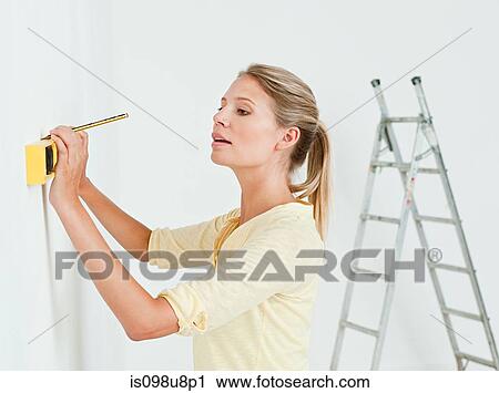 Young woman using spirit level on wall View Large Photo Image Stock Image - Young woman using spirit level on wall. Fotosearch