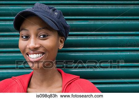 Stock Image - Young woman wearing cap. Fotosearch