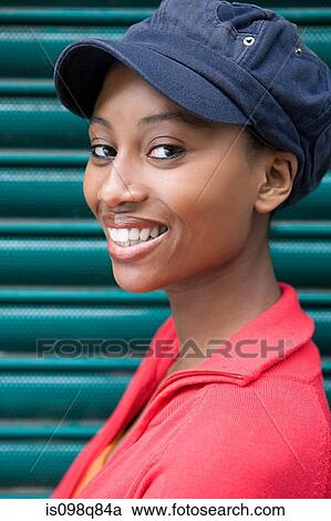Stock Image - Young woman wearing cap. Fotosearch