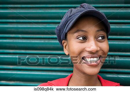 Stock Image - Young woman wearing cap. Fotosearch