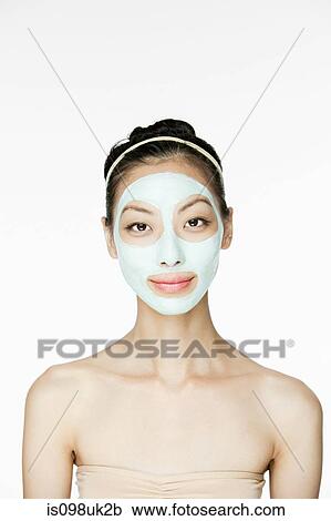 Stock Image - Young woman wearing face mask. Fotosearch