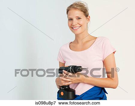 Young woman with an electric drill View Large Photo Image Stock Photo - Young woman with an electric drill. Fotosearch