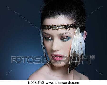 Stock Image - Young woman with feather headdress. Fotosearch