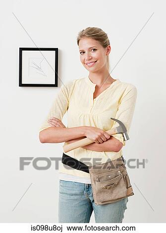 Young woman with hammer and picture on wall View Large Photo Image Stock Image - Young woman with hammer and picture on wall. Fotosearch