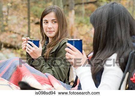 Young women having drink at campsite View Large Photo Image Picture - Young women having drink at campsite. Fotosearch