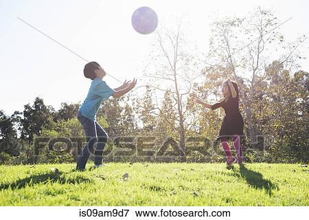 Brother and sister playing catch with ball in park View Large Photo Image Stock Photo - Brother and sister playing catch with ball in park. Fotosearch