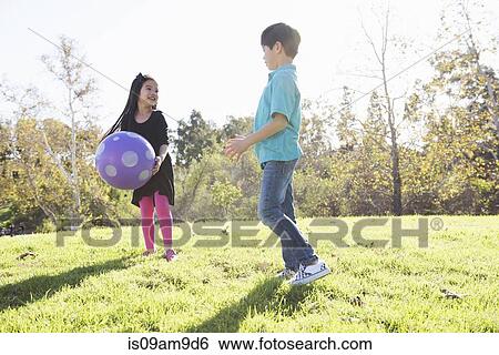 Brother and sister playing with ball in park View Large Photo Image Stock Photograph - Brother and sister playing with ball in park. Fotosearch