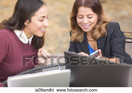 Business women using laptops and phone outdoors View Large Photo Image Stock Image - Business women using laptops and phone outdoors. Fotosearch