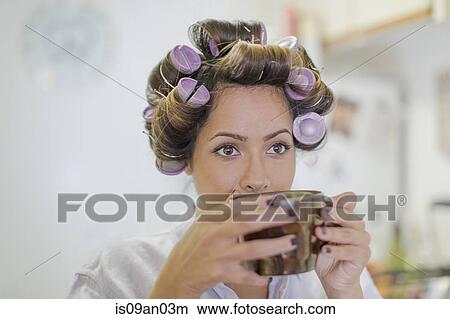 Close up of mid adult woman wearing hair rollers drinking coffee View Large Photo Image Picture - Close up of mid adult woman wearing hair rollers drinking coffee. Fotosearch