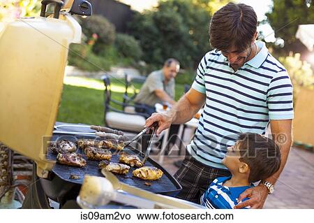 Father and son at barbecue grill in garden View Large Photo Image Picture - Father and son at barbecue grill in garden. Fotosearch