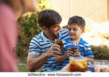 Picture - Father and son toasting in garden. Fotosearch