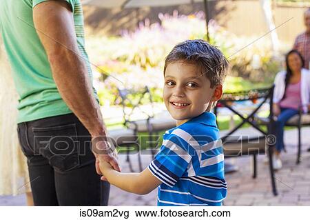Stock Image - Father with son looking over shoulder. Fotosearch