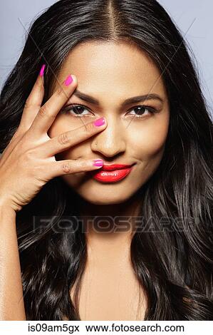 Stock Photo - Female model covering face with fingers. Fotosearch