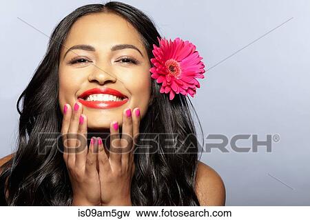 Stock Photo - "Female model smiling, flower on hair". Fotosearch