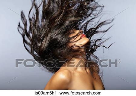 Stock Image - Female model throwing hair back. Fotosearch