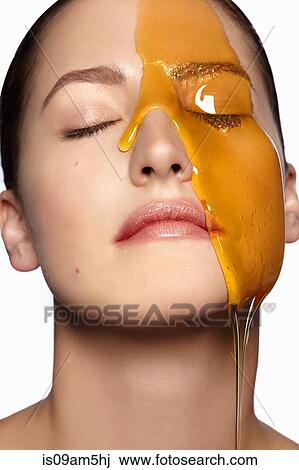 Female model's face partially covered in honey View Large Photo Image Stock Image - Female model's face partially covered in honey. Fotosearch