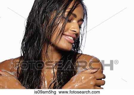 Stock Image - Female model's shoulder covered in soap bubbles. Fotosearch