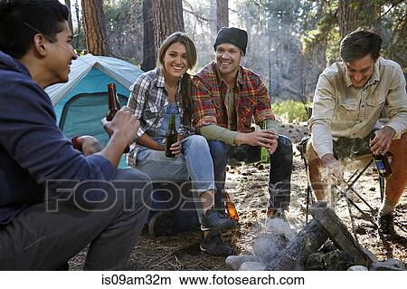 "Four young adult friends chatting by campfire in forest, Los Angeles, California, USA" View Large Photo Image Picture - "Four young adult friends chatting by campfire in forest, Los Angeles, California, USA". Fotosearch