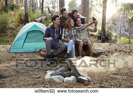 "Four young adult friends taking smartphone selfie by campfire in forest, Los Angeles, California, USA" View Large Photo Image Stock Image - "Four young adult friends taking smartphone selfie by campfire in forest, Los Angeles, California, USA". Fotosearch