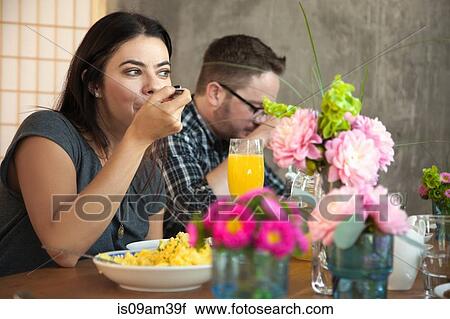 Friends at dinner table eating meal View Large Photo Image Stock Image - Friends at dinner table eating meal. Fotosearch