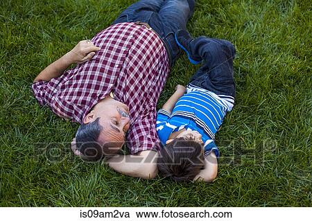 Grandfather and grandson relaxing on grass View Large Photo Image Stock Image - Grandfather and grandson relaxing on grass. Fotosearch