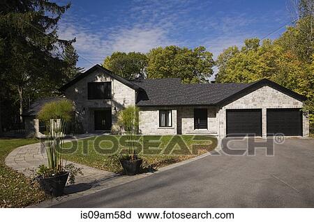 Stock Image - Grey stone luxury home with drive and garden. Fotosearch