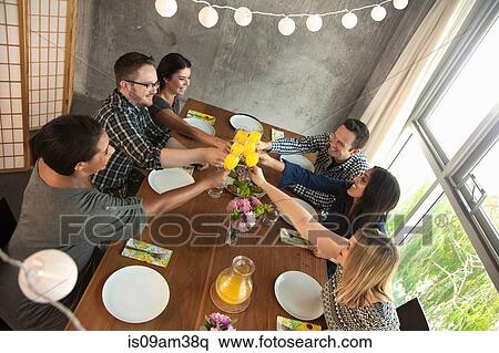 "Group of friends around table, raising glasses, making toast" View Large Photo Image Stock Photography - "Group of friends around table, raising glasses, making toast". Fotosearch