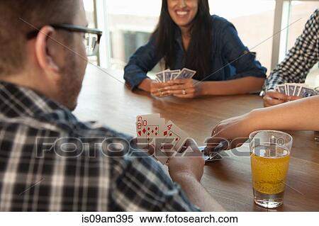 Group of friends playing cards around table View Large Photo Image Stock Photography - Group of friends playing cards around table. Fotosearch