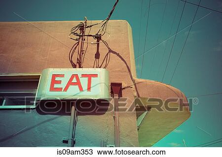 Stock Image - "Low angle view of eat sign on cafe wall, Pescardero, California, USA". Fotosearch